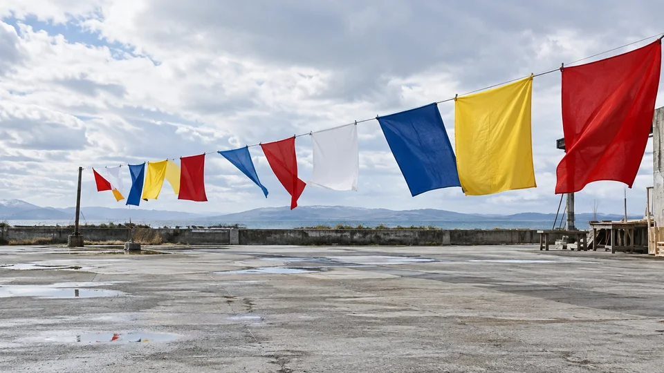 Prototype flags tested outdoors in changing wind, clean documentary design photograph with bold geometry.